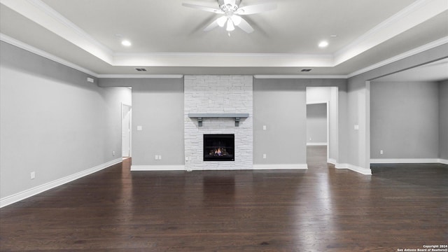 unfurnished living room featuring a fireplace, dark hardwood / wood-style floors, ceiling fan, and crown molding