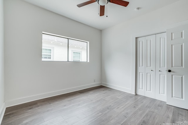 unfurnished bedroom with ceiling fan, a closet, and light hardwood / wood-style floors