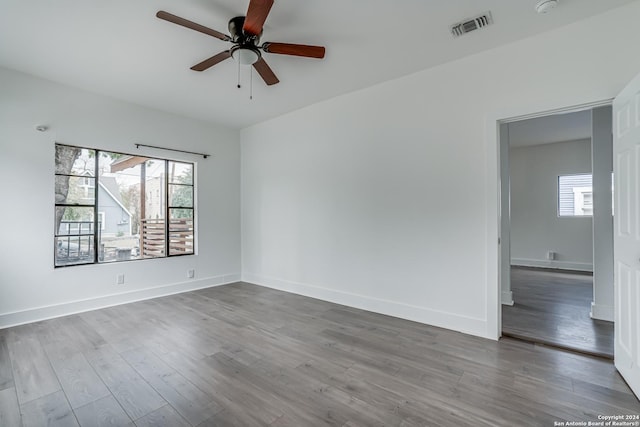 spare room with hardwood / wood-style flooring, ceiling fan, and a healthy amount of sunlight