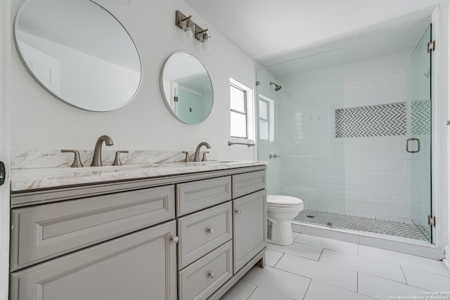 bathroom with tile patterned floors, vanity, toilet, and walk in shower