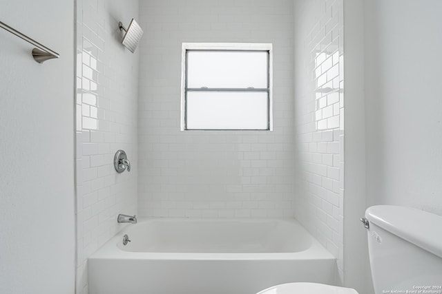 bathroom with tiled shower / bath and toilet