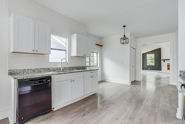 kitchen featuring sink, hanging light fixtures, black dishwasher, light hardwood / wood-style floors, and white cabinetry