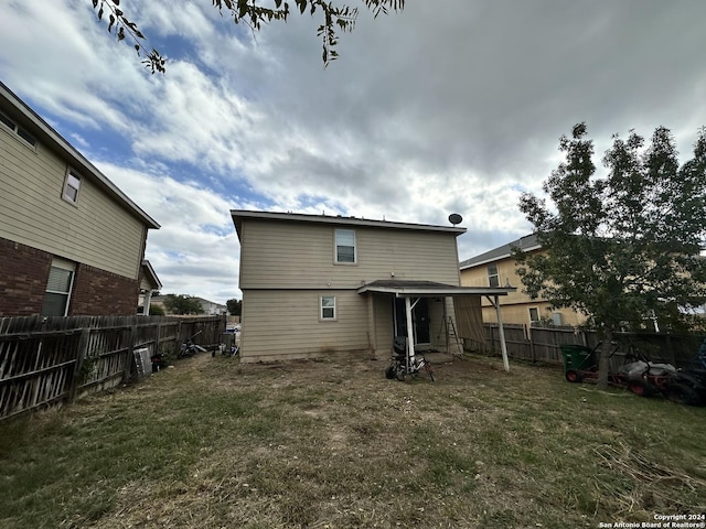 rear view of property featuring a lawn