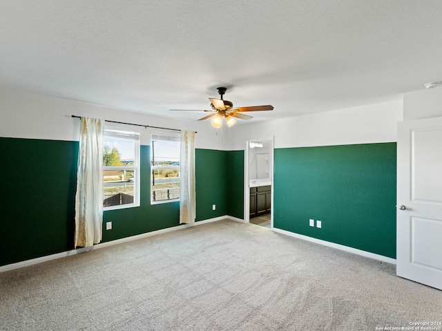 carpeted empty room featuring ceiling fan and a textured ceiling