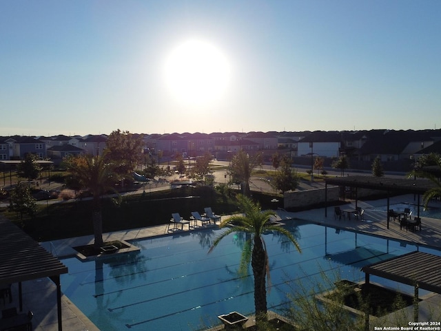 pool at dusk featuring a patio area