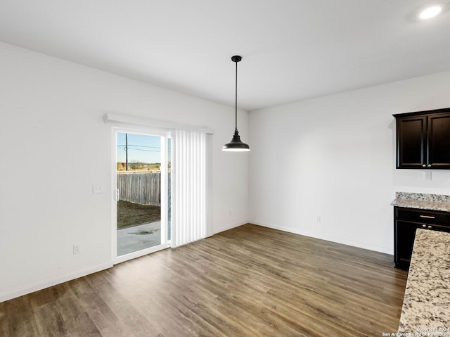 unfurnished dining area with dark wood-type flooring