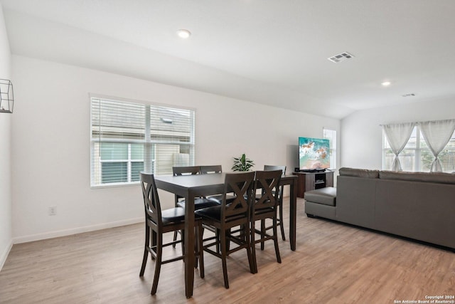 dining space with light hardwood / wood-style flooring and lofted ceiling