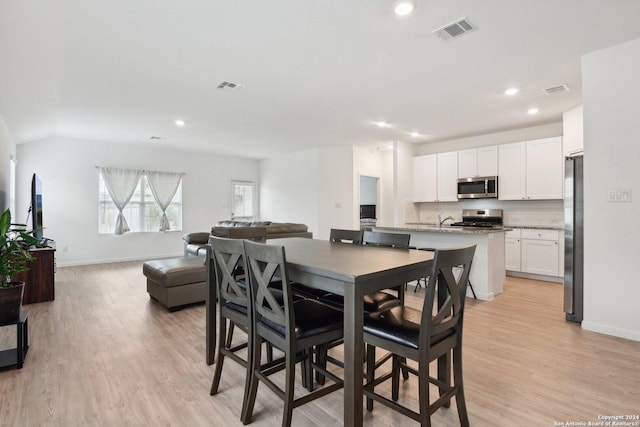 dining space with sink and light wood-type flooring