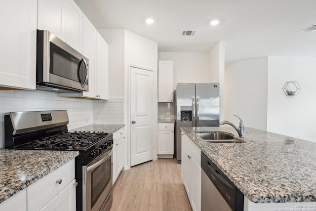 kitchen featuring white cabinets, stainless steel appliances, and sink