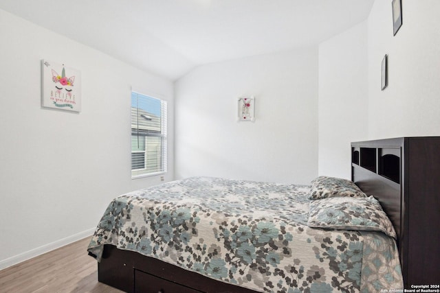 bedroom with light hardwood / wood-style floors and vaulted ceiling