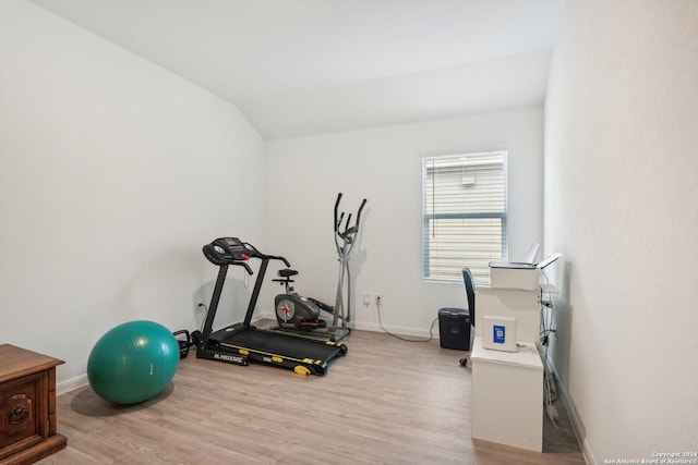 exercise room featuring light hardwood / wood-style floors and lofted ceiling