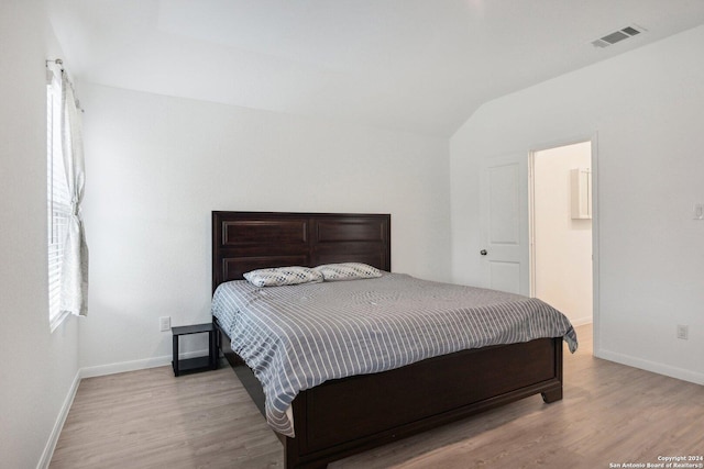 bedroom featuring lofted ceiling and light wood-type flooring