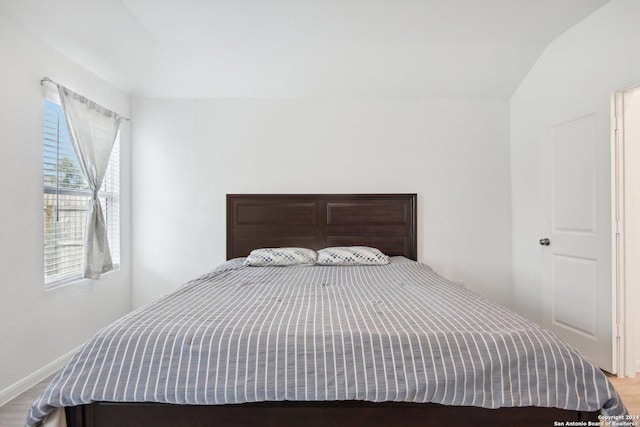 bedroom featuring wood-type flooring and vaulted ceiling