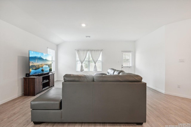 living room with light hardwood / wood-style floors and lofted ceiling