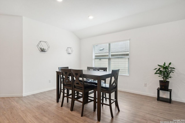 dining space with lofted ceiling and light wood-type flooring