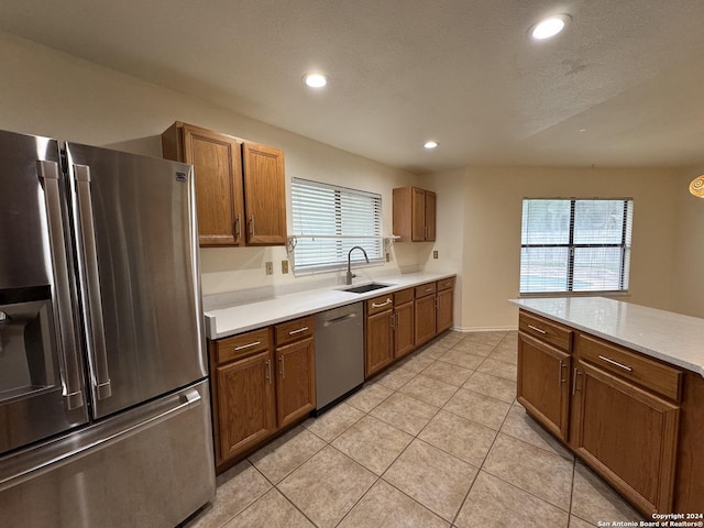 kitchen with sink, light tile patterned floors, plenty of natural light, and appliances with stainless steel finishes