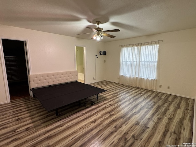 interior space featuring ensuite bathroom, a textured ceiling, ceiling fan, a spacious closet, and dark hardwood / wood-style floors