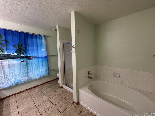 bathroom with toilet, a textured ceiling, tile patterned floors, and plus walk in shower