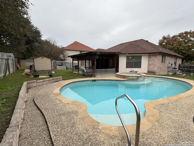 view of pool with a shed and an in ground hot tub