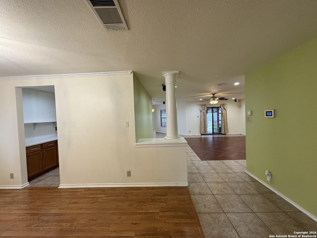 empty room featuring light hardwood / wood-style floors, decorative columns, and ceiling fan