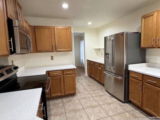 kitchen featuring light tile patterned floors and stainless steel appliances