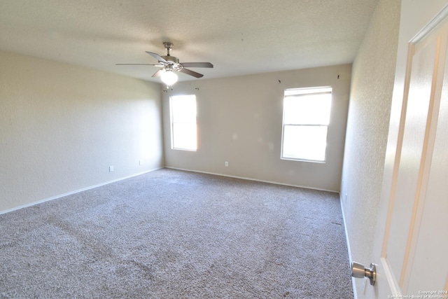 empty room with ceiling fan, carpet floors, and a textured ceiling