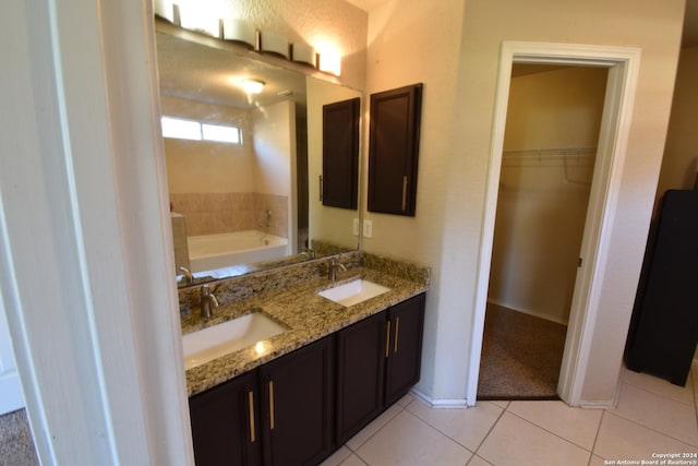 bathroom featuring tile patterned floors, vanity, and a bath