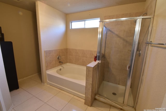 bathroom featuring tile patterned flooring, independent shower and bath, and a textured ceiling