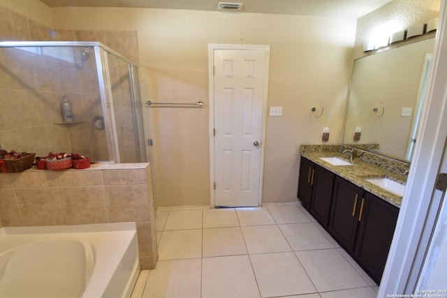 bathroom with tile patterned flooring, shower with separate bathtub, vanity, and a textured ceiling