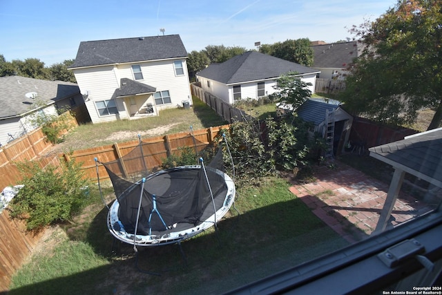 back of property featuring a lawn, a patio area, and a trampoline