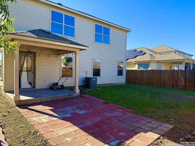 rear view of house with a yard, a patio, and cooling unit