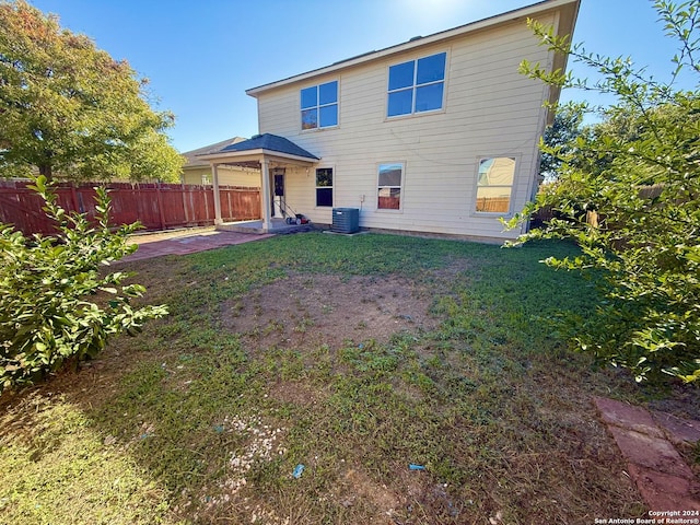 back of house with a yard and cooling unit