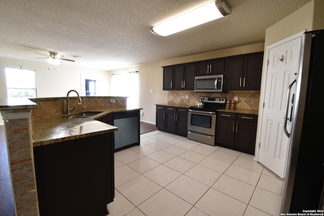 kitchen with light tile patterned flooring, stainless steel appliances, plenty of natural light, and sink