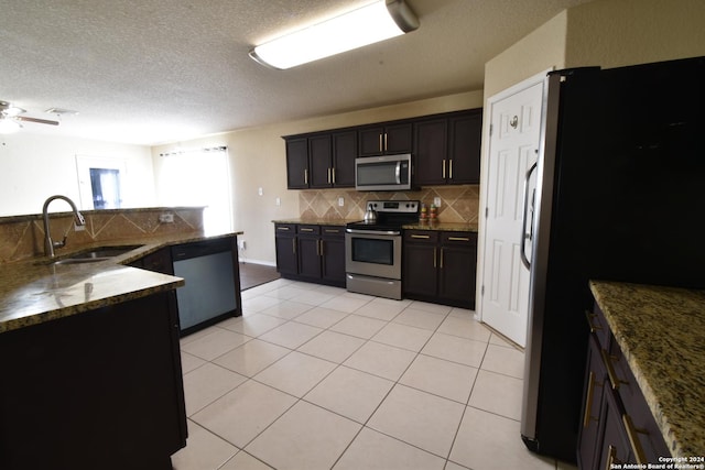 kitchen featuring ceiling fan, sink, stainless steel appliances, tasteful backsplash, and light tile patterned flooring