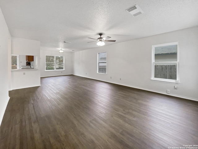 unfurnished living room with ceiling fan, dark hardwood / wood-style flooring, and a textured ceiling