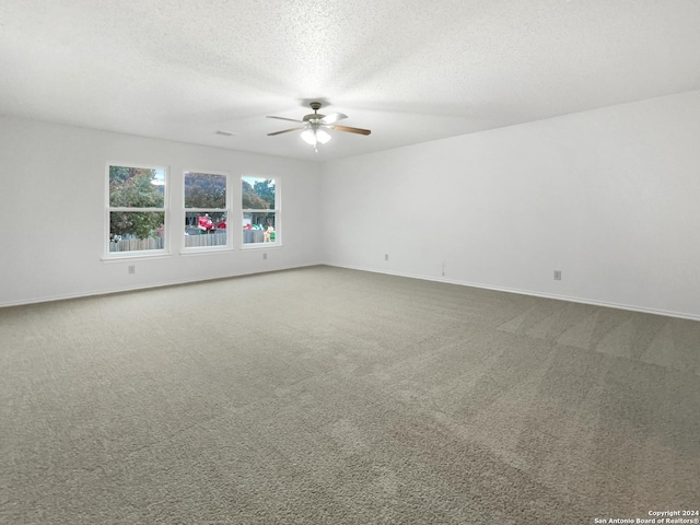 spare room with carpet, a textured ceiling, and ceiling fan