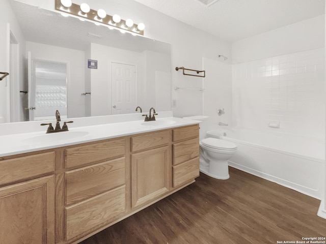 full bathroom with a textured ceiling, hardwood / wood-style flooring, toilet, and shower / bathtub combination