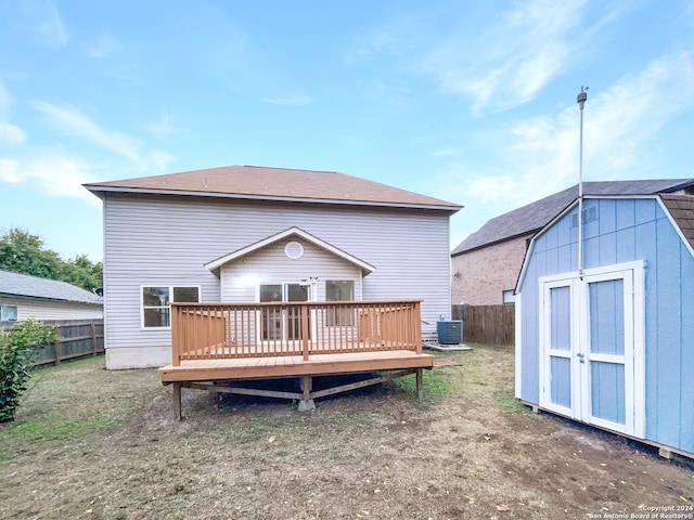 rear view of house with a deck, a lawn, a storage shed, and central air condition unit