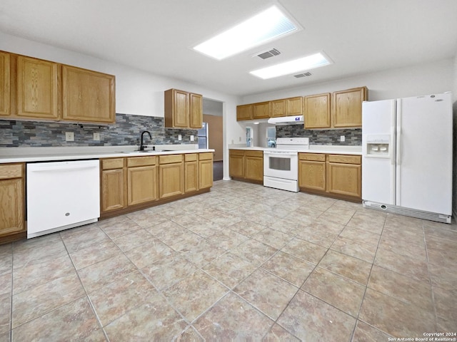 kitchen featuring white appliances, sink, and tasteful backsplash