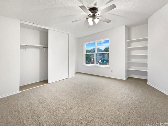 unfurnished bedroom featuring carpet, ceiling fan, and a textured ceiling