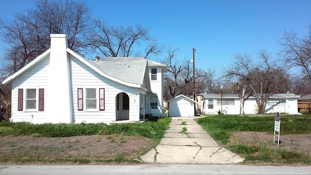 view of front of home featuring a garage and an outbuilding