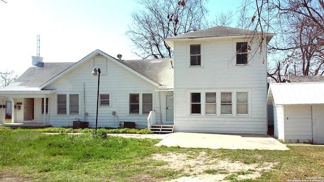 rear view of house with a patio and a lawn