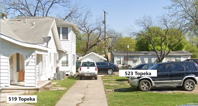 view of side of property featuring central AC unit and a yard