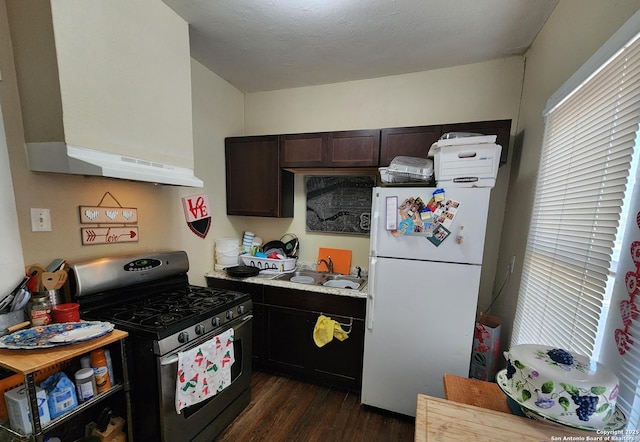 kitchen featuring dark hardwood / wood-style floors, sink, white refrigerator, gas stove, and dark brown cabinets