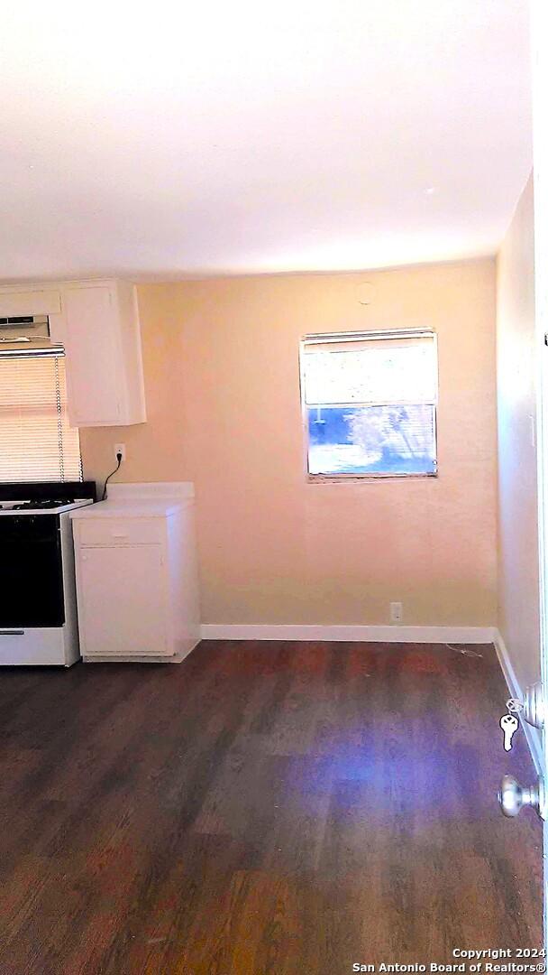 clothes washing area with dark wood-type flooring and washing machine and clothes dryer