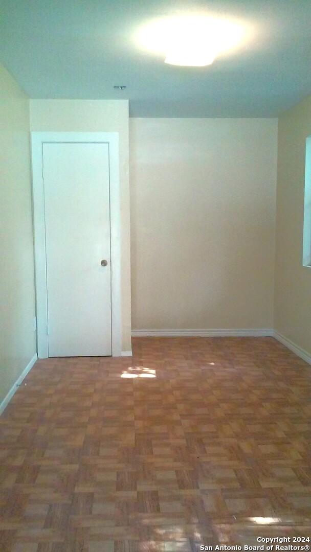 spare room featuring dark parquet floors