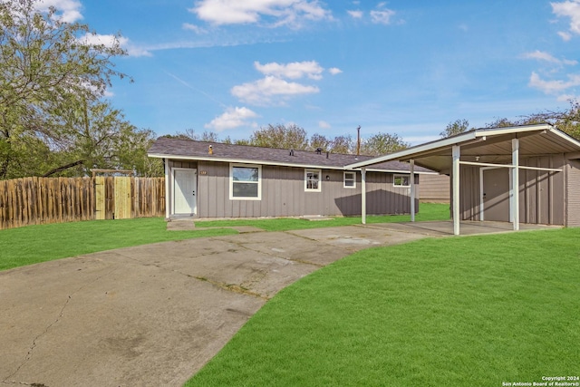 rear view of house featuring a lawn and fence