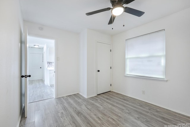 unfurnished bedroom featuring ceiling fan, a closet, and light hardwood / wood-style floors