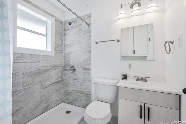 bathroom featuring vanity, toilet, and a tile shower