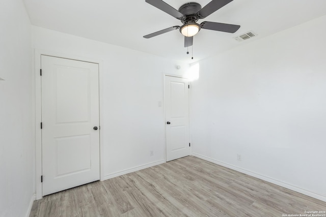 unfurnished bedroom featuring a closet, light hardwood / wood-style floors, and ceiling fan